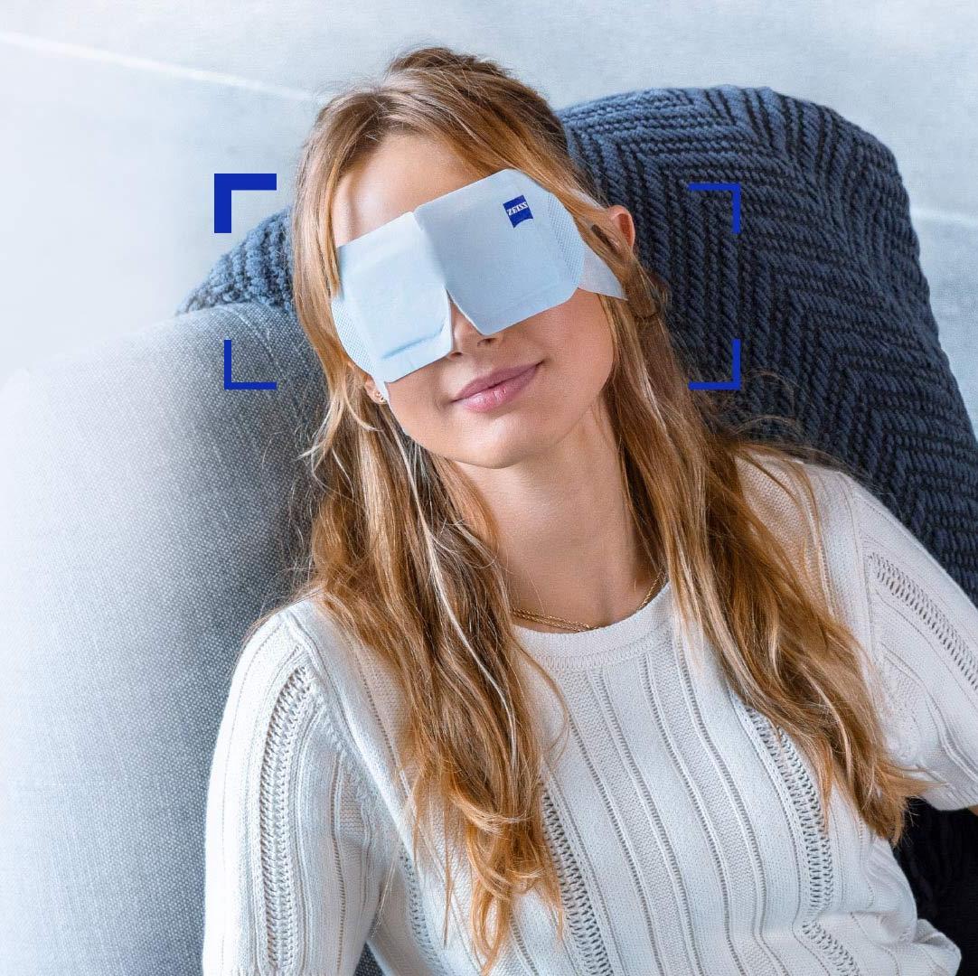 A women wearing ZEISS Warm Eye Mask and relaxing in a chair.