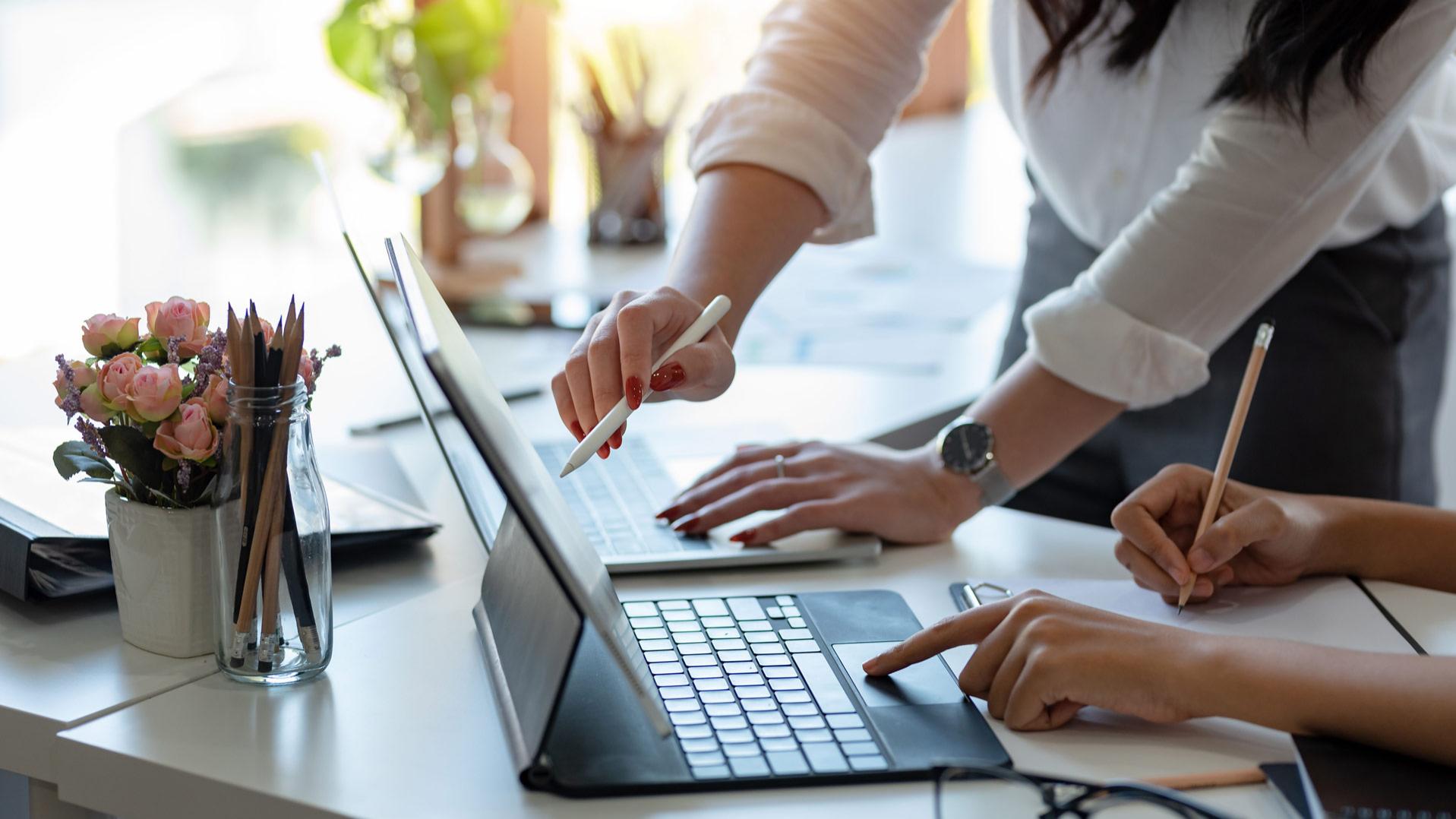 Image of two people working on a computer