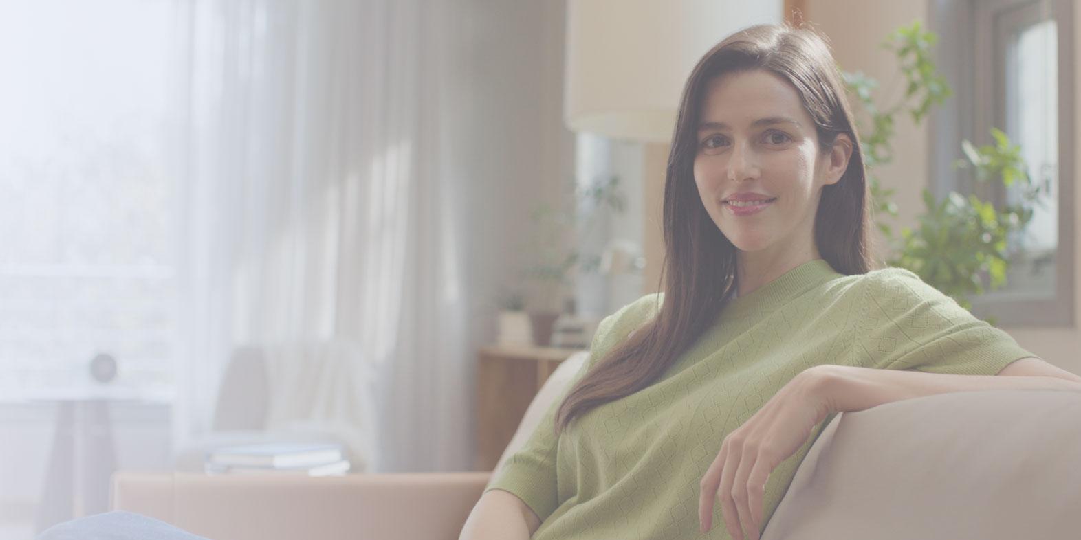 Woman smiling peacefully in a living room setting, reflecting visual independence and comfort post-ZEIS SMILE surgery.