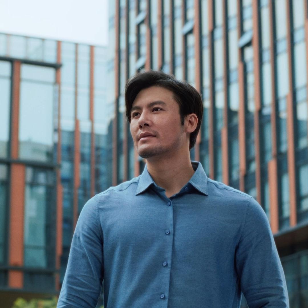 Man smiling outdoors in a city environment, representing clarity and confidence following PRK laser vision treatment.