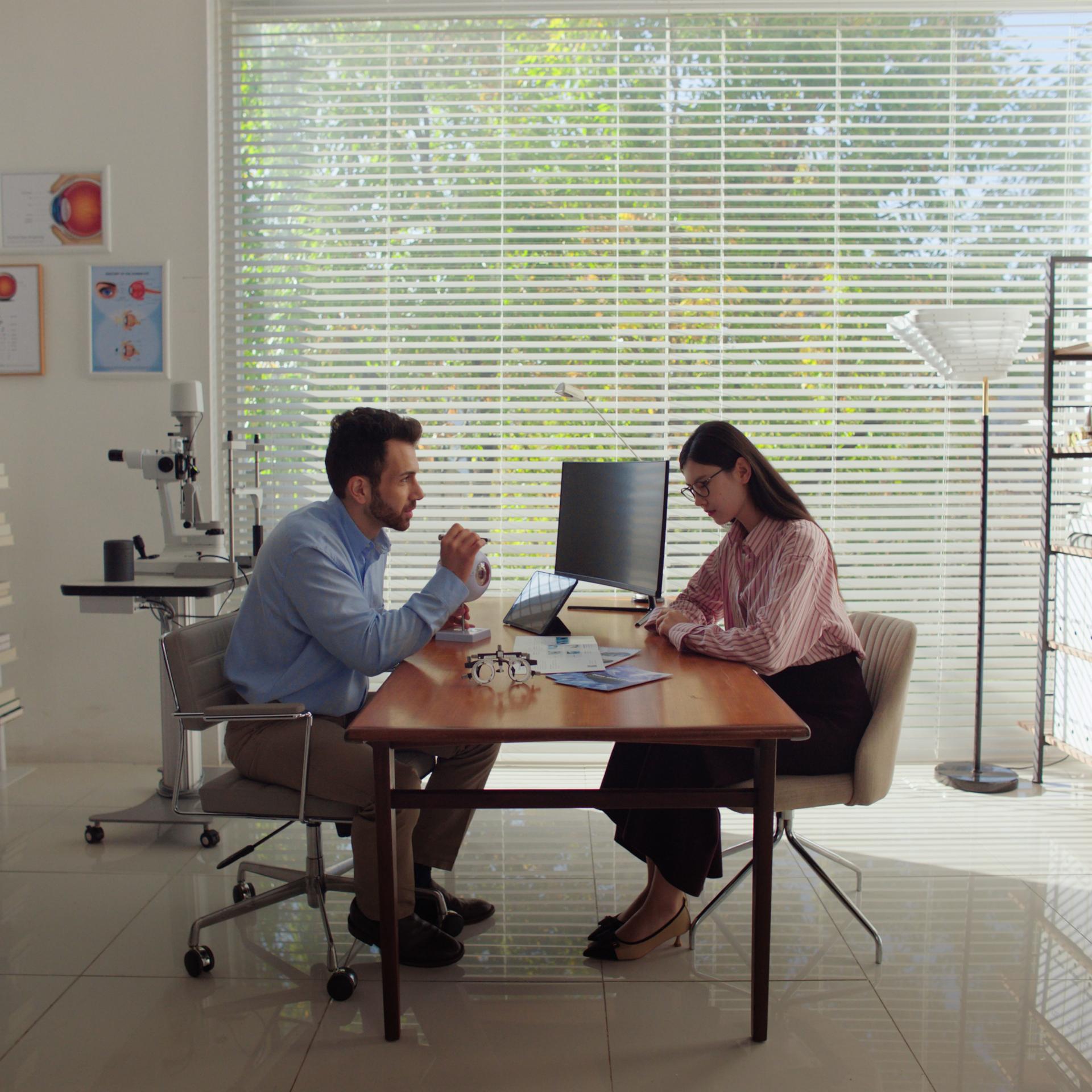 Doctor and patient in discussion about laser vision correction with ZEISS SMILE before treatment.