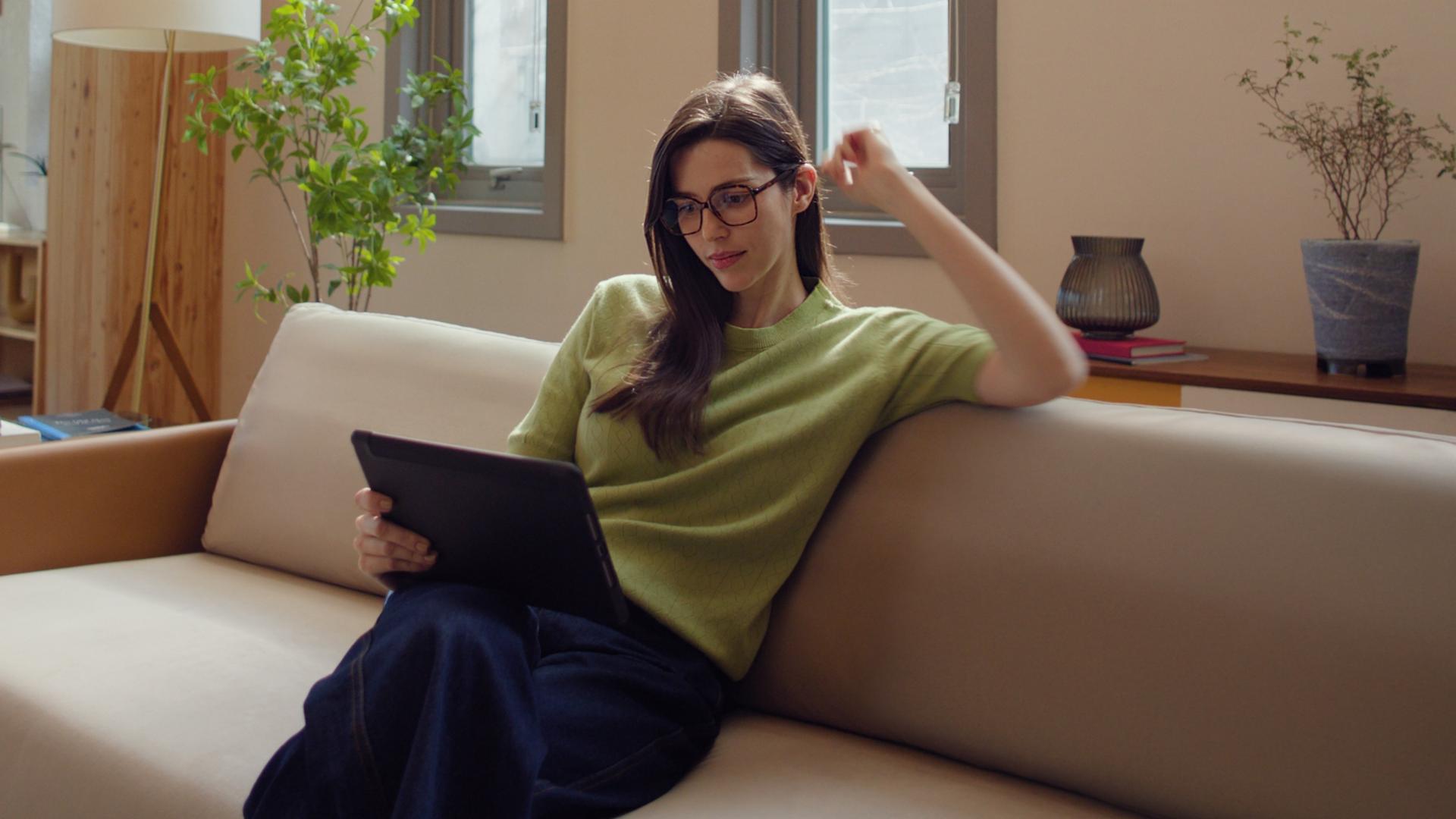 Woman in livingroom comparing treatment options for laser vision correction.