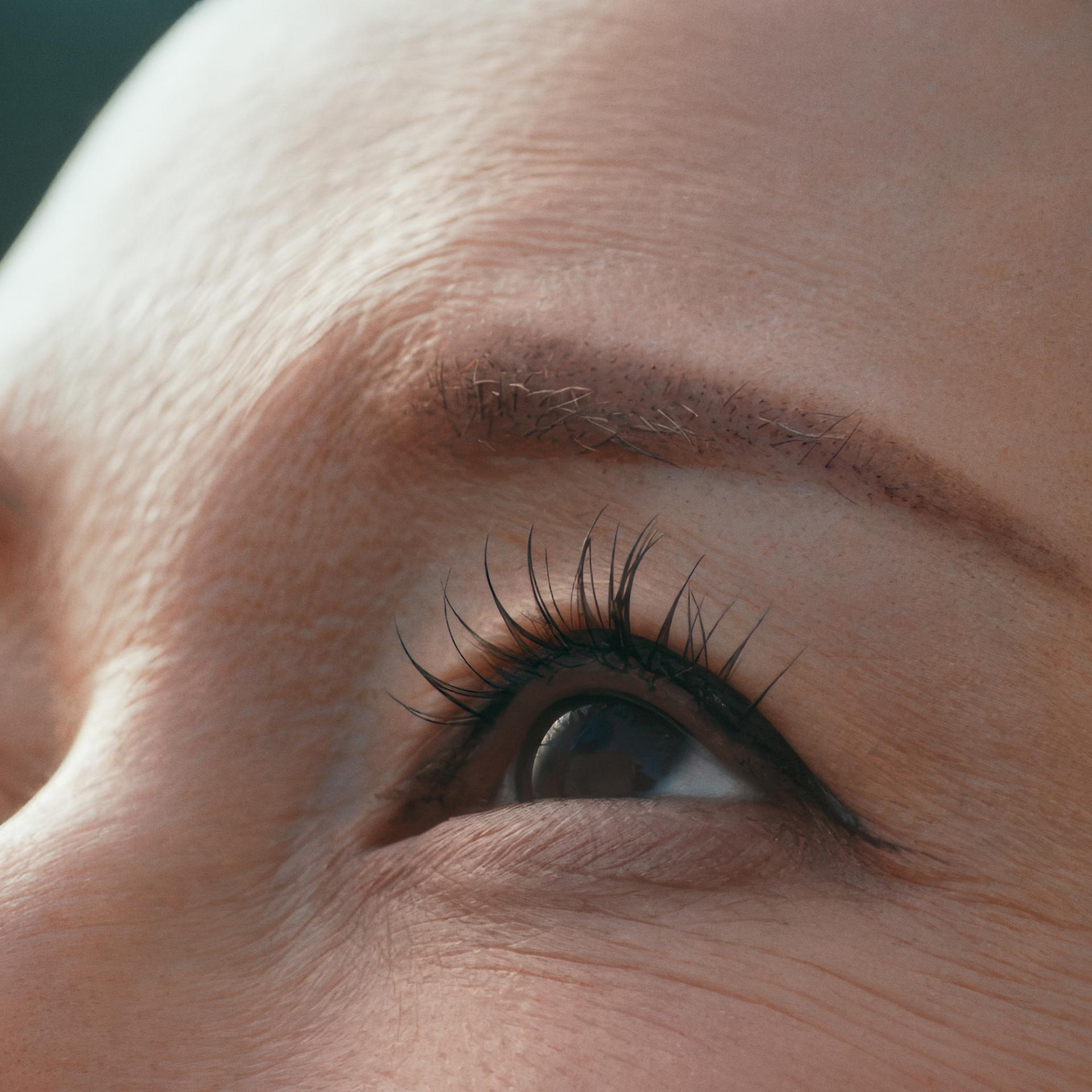 Snippet of the eye of an asian woman looking into the upper left corner of the image.