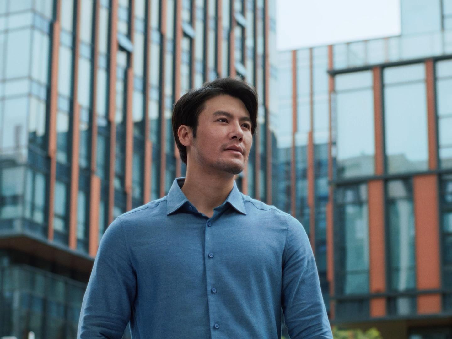 Man smiling outdoors in a city environment, representing clarity and confidence following PRK laser vision treatment.