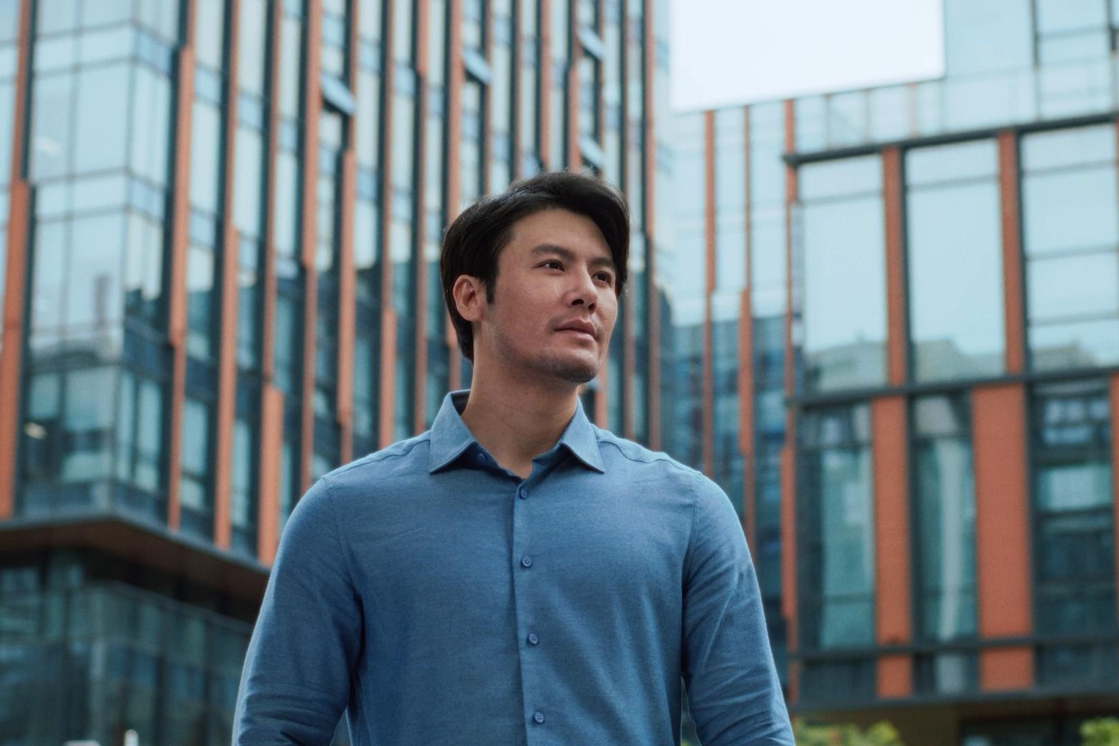 Man smiling outdoors in a city environment, representing clarity and confidence following PRK laser vision treatment.