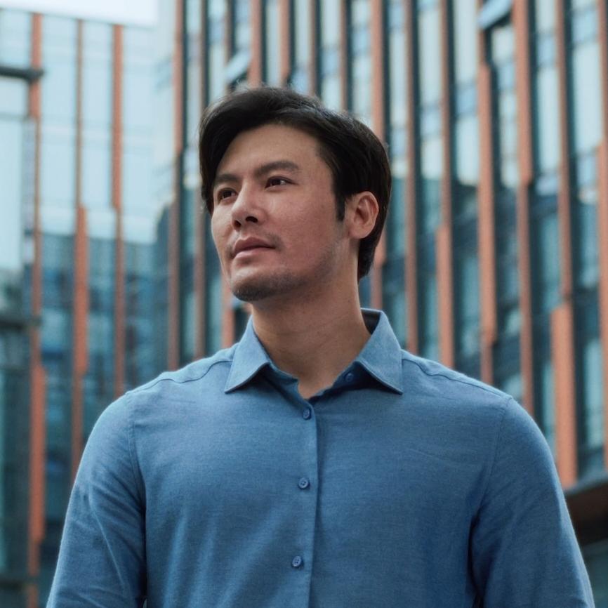 Man smiling outdoors in a city environment, representing clarity and confidence following PRK laser vision treatment.