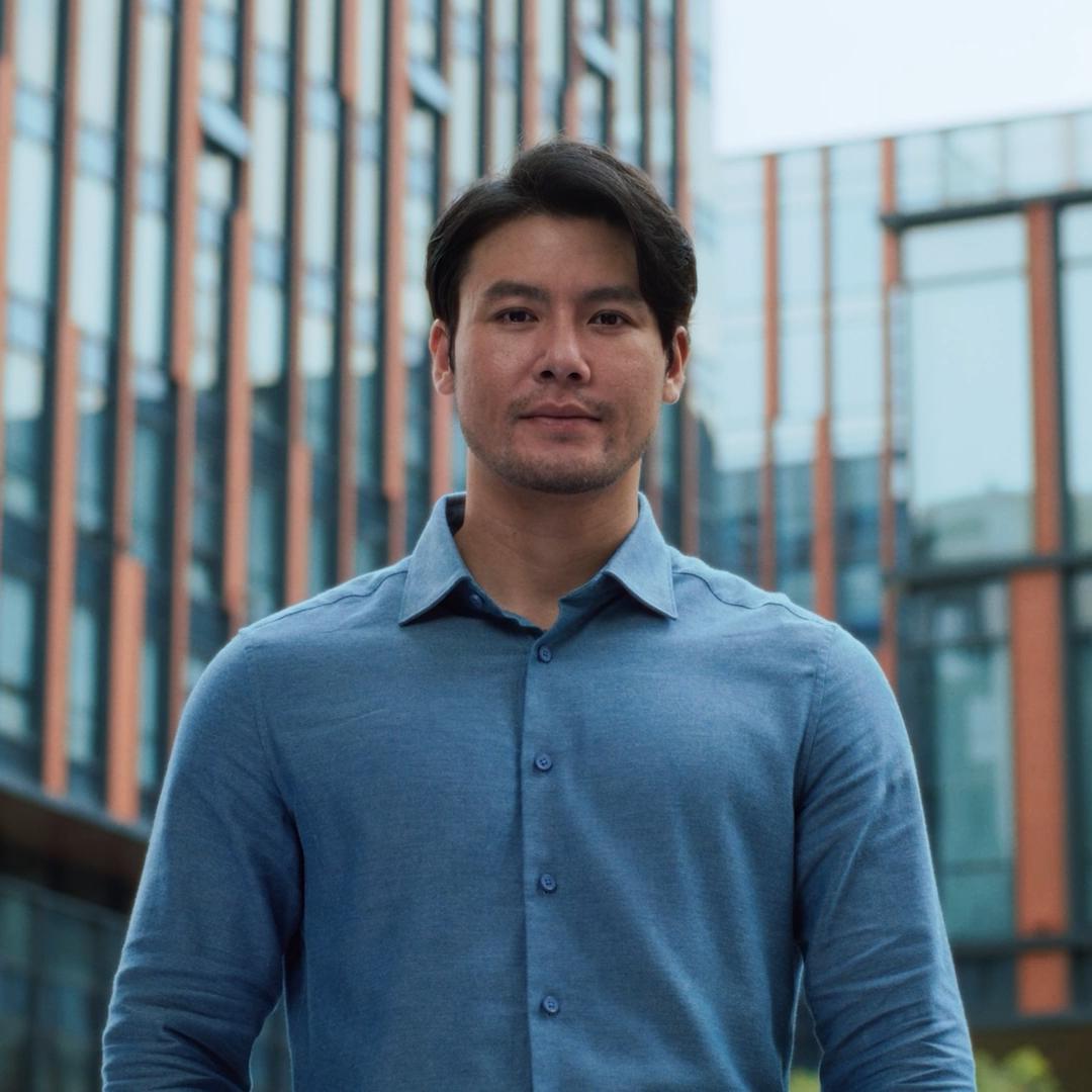 Man smiling outdoors in a city environment, representing clarity and confidence following PRK laser vision treatment.
