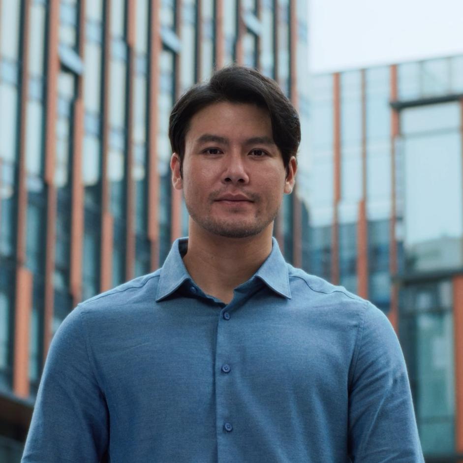 Man smiling outdoors in a city environment, representing clarity and confidence following PRK laser vision treatment.