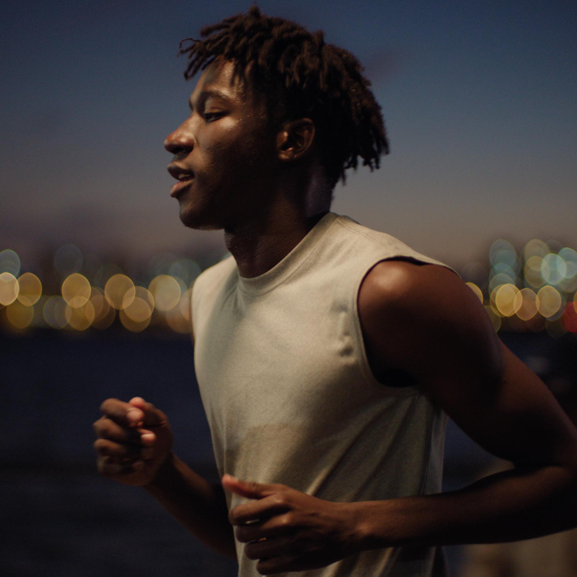 Runner in sleeveless shirt at dusk, embodying dynamic clarity and visual confidence post-PRK.