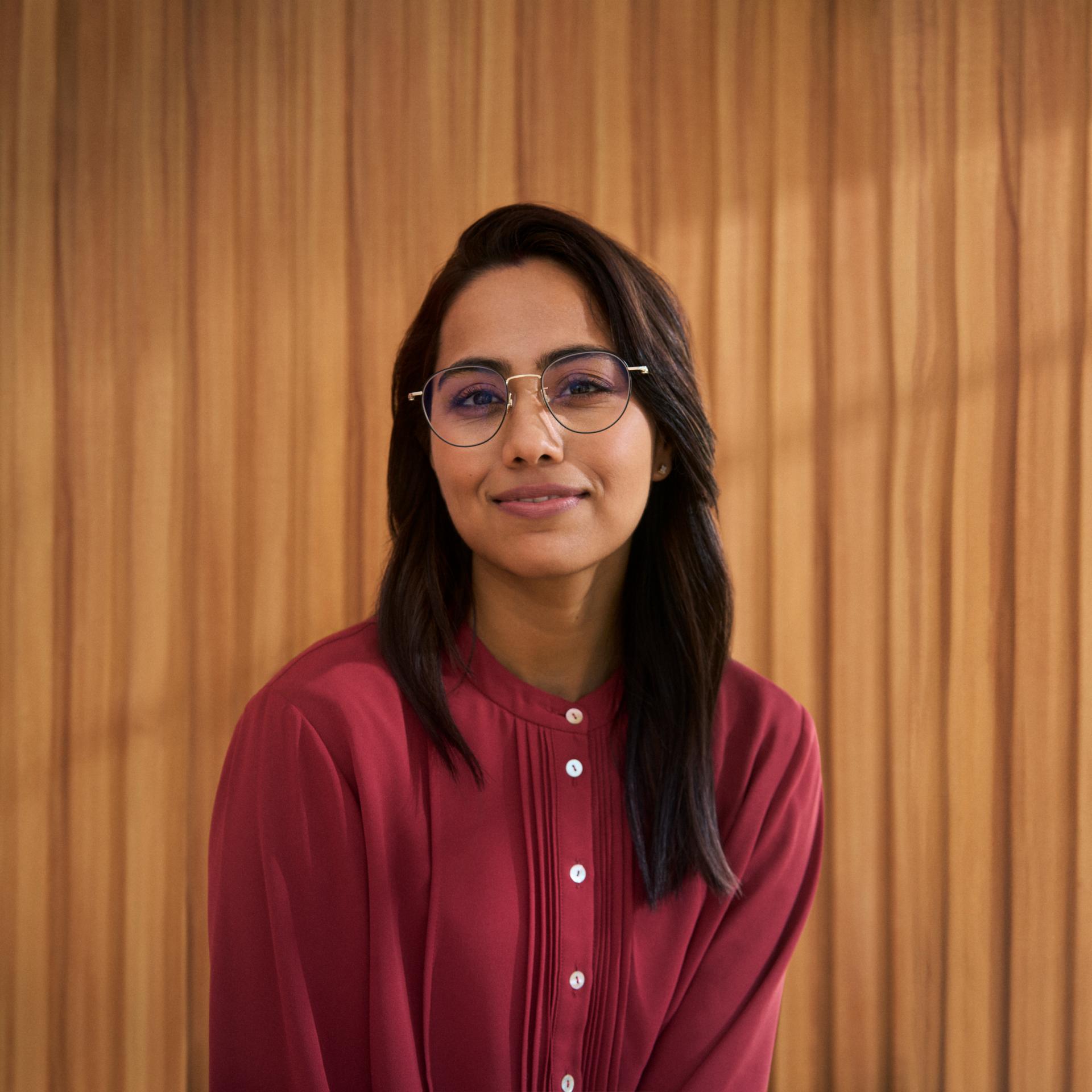 Portrait of a young woman in glasses, representing potential eligibility for laser vision correction with ZEISS SMILE.