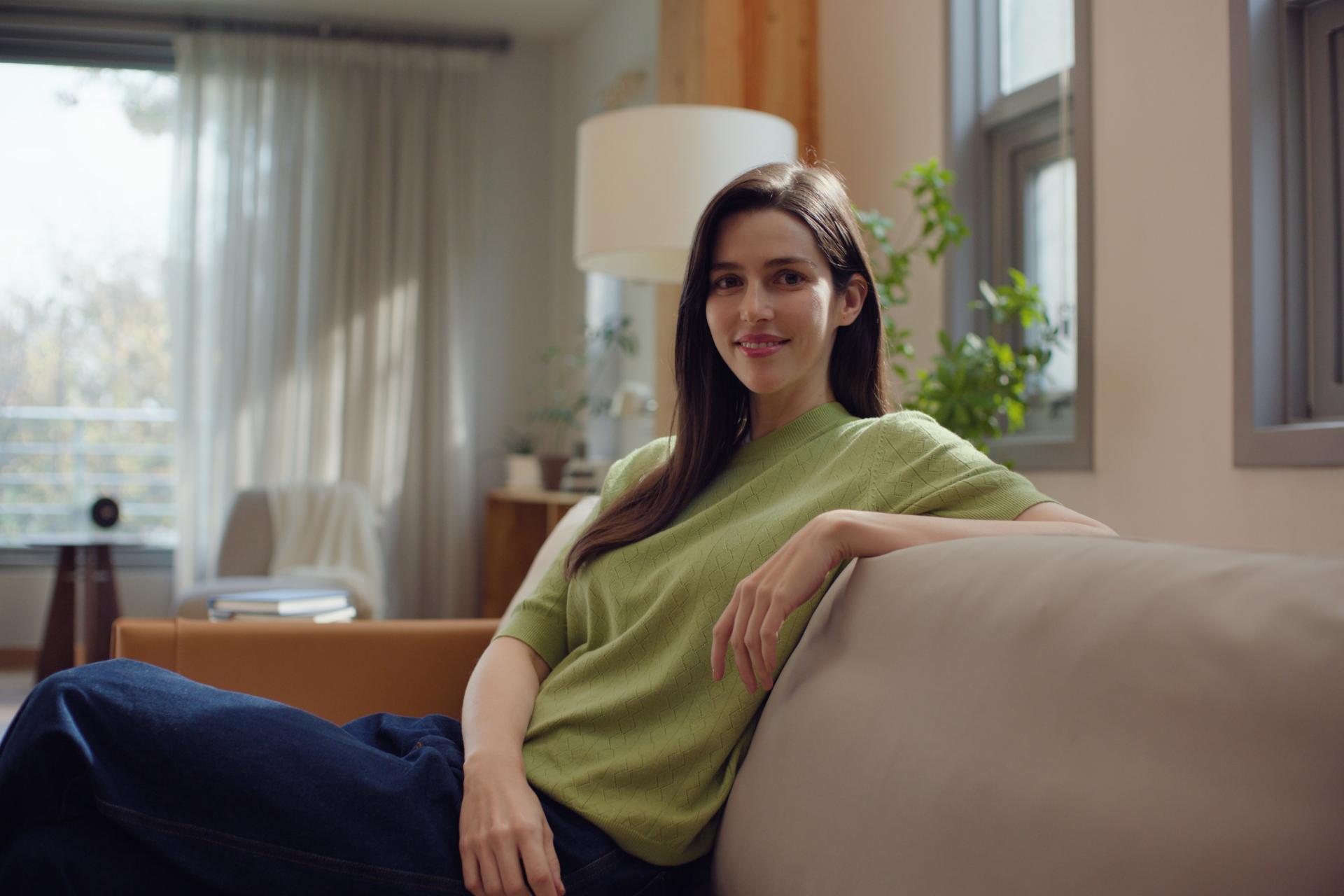Woman smiling peacefully in a living room setting, reflecting visual independence and comfort post-ZEIS SMILE surgery.