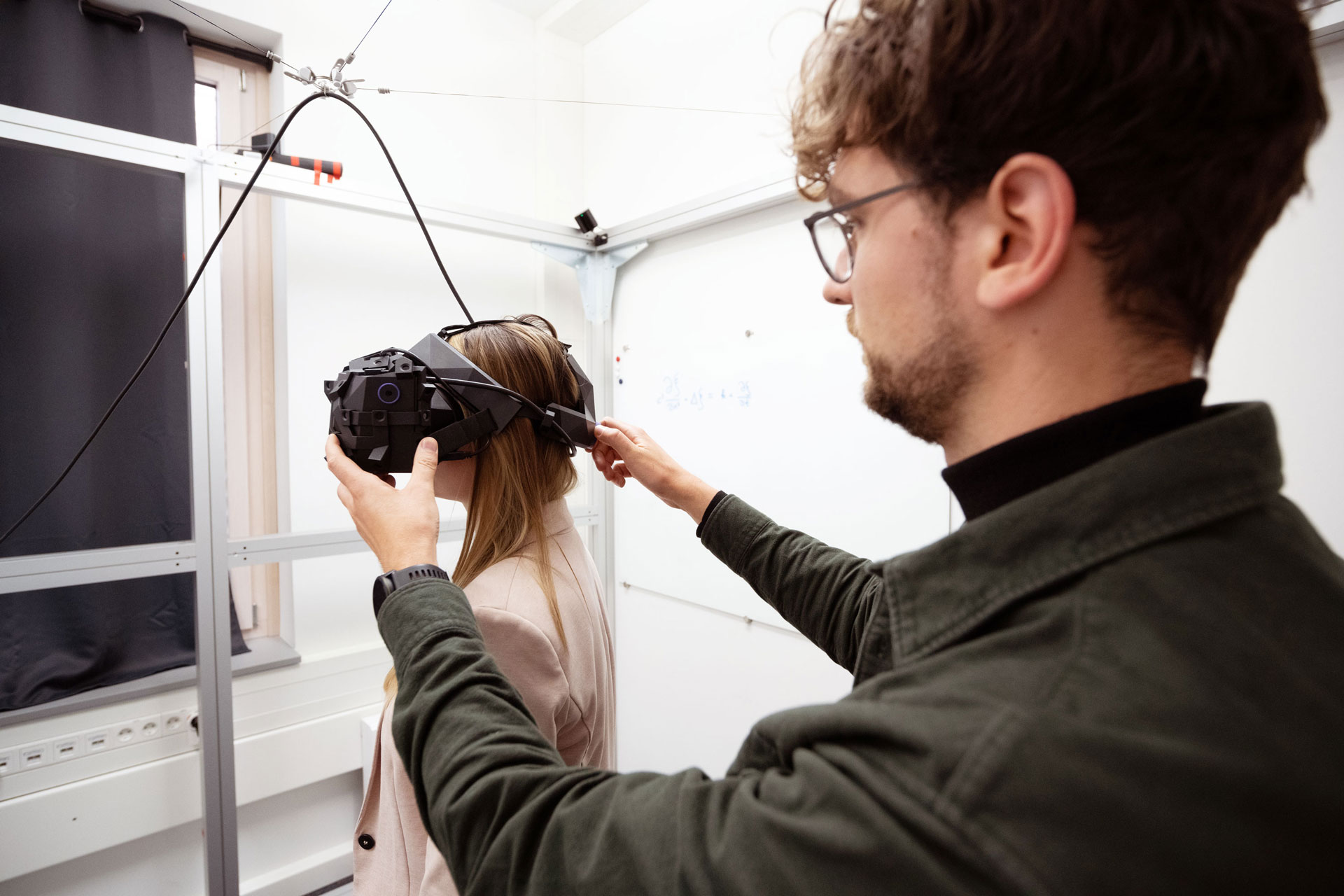 Male scientists puts VR glasses on a women