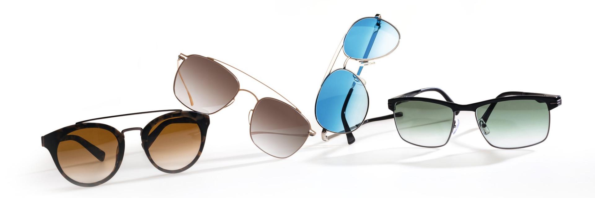 Four sunglasses with different frames and styles. The lenses of each sunglasses have a different color.