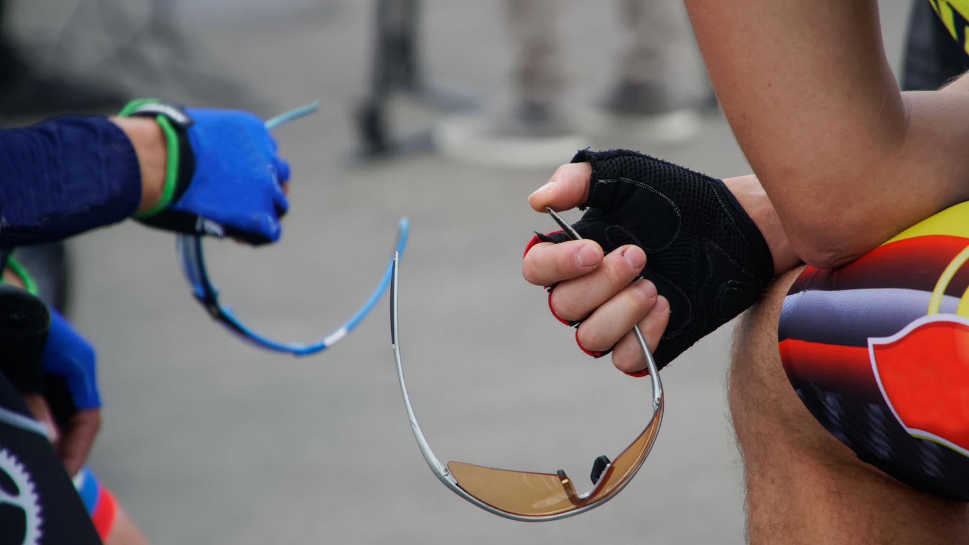 Active lifestyle. Two athletes - a cyclist holder of safety glasses before the start of the competition