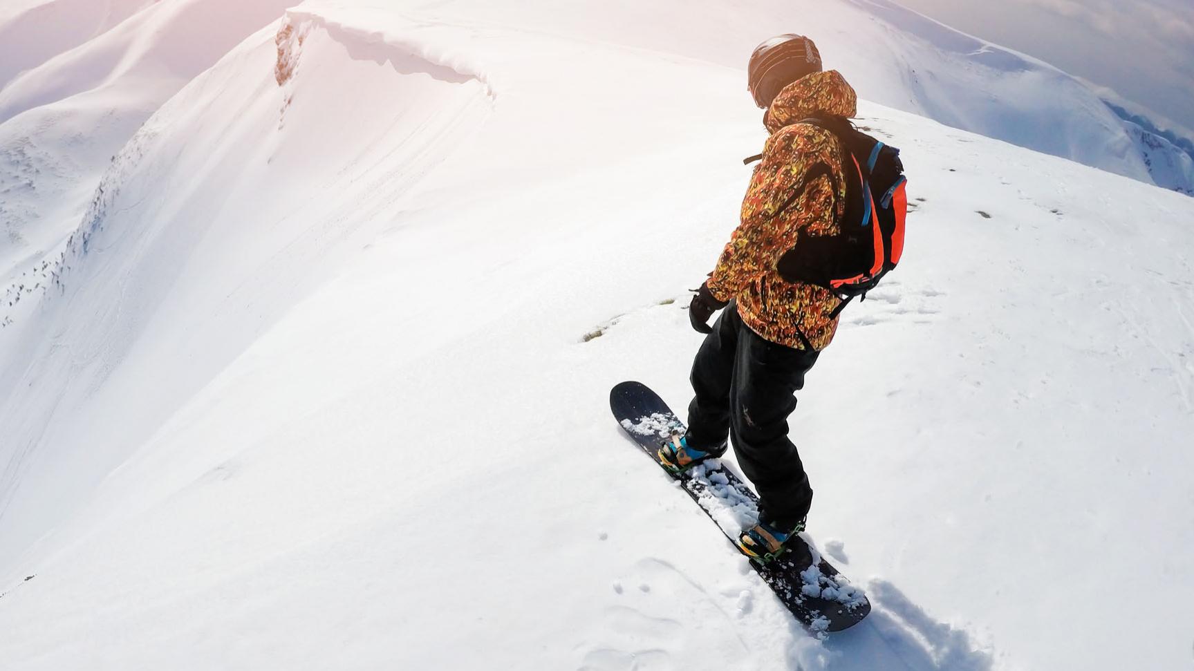 Freeriders on steep slope ready to drop in fresh powder snow