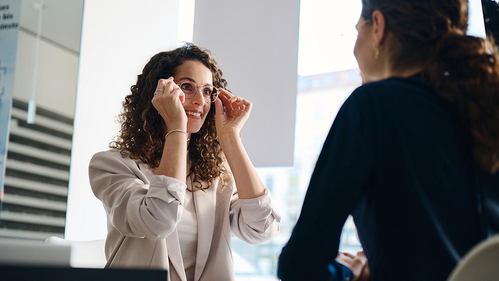 Happy and suprised-looking woman for the first time wearing her new ZEISS eyeglasses
