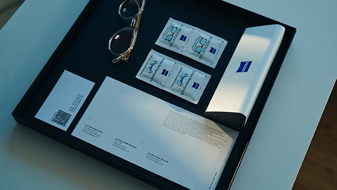 An elegant dark tray with neatly composed new ZEISS spectacles and accessories on it