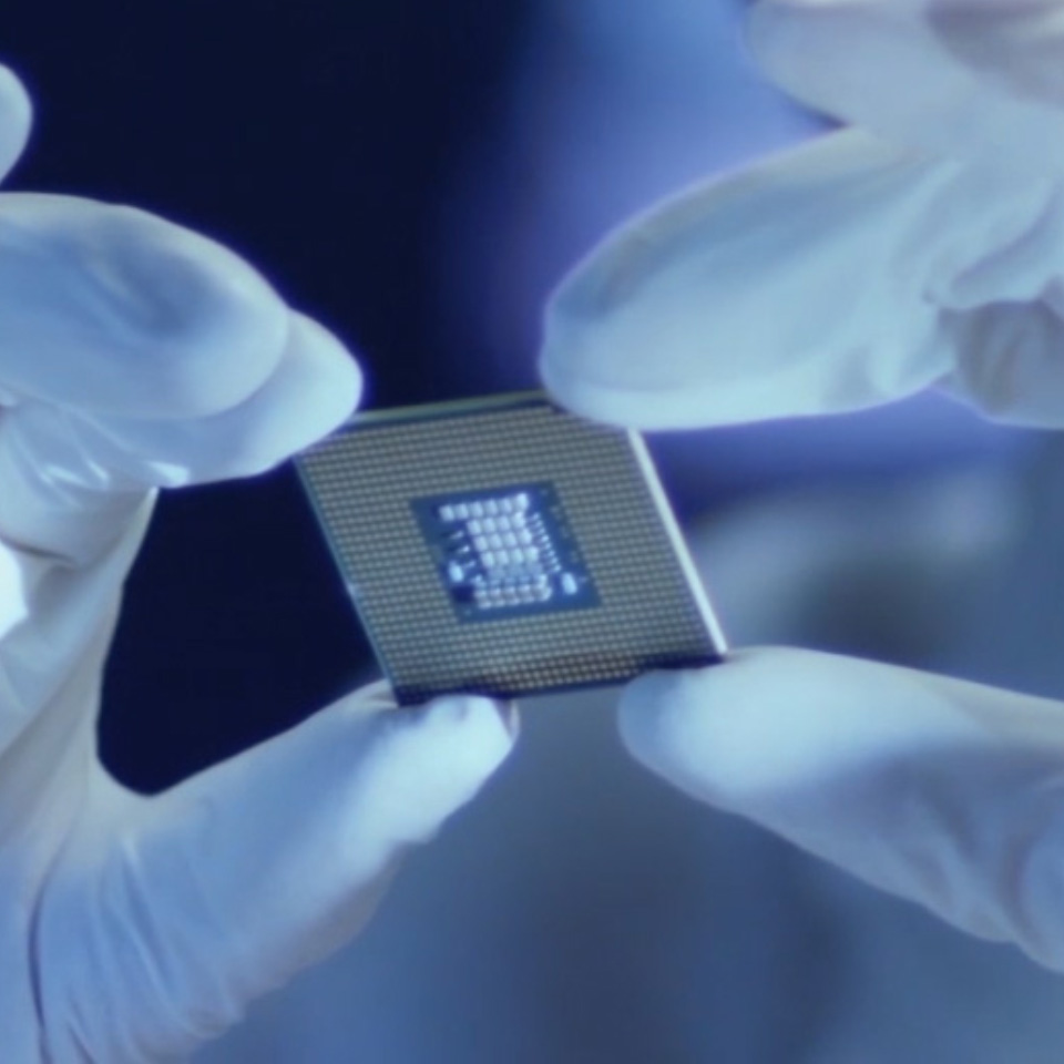 실험실 장갑을 낀 사람이 들고 있는 마이크로칩의 이미지. 