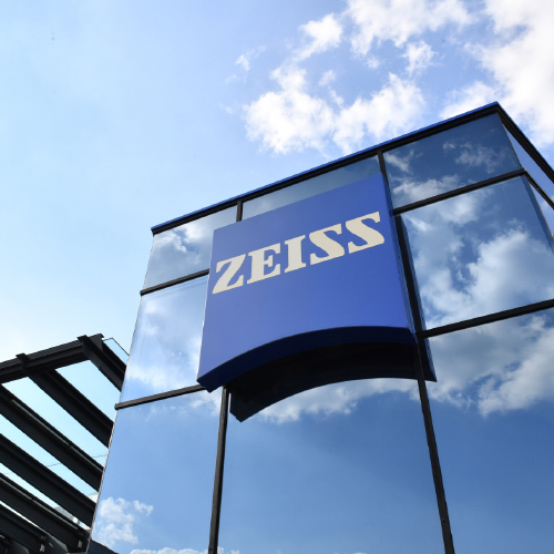 Une image d’un bâtiment moderne en verre portant un grand logo ZEISS. 