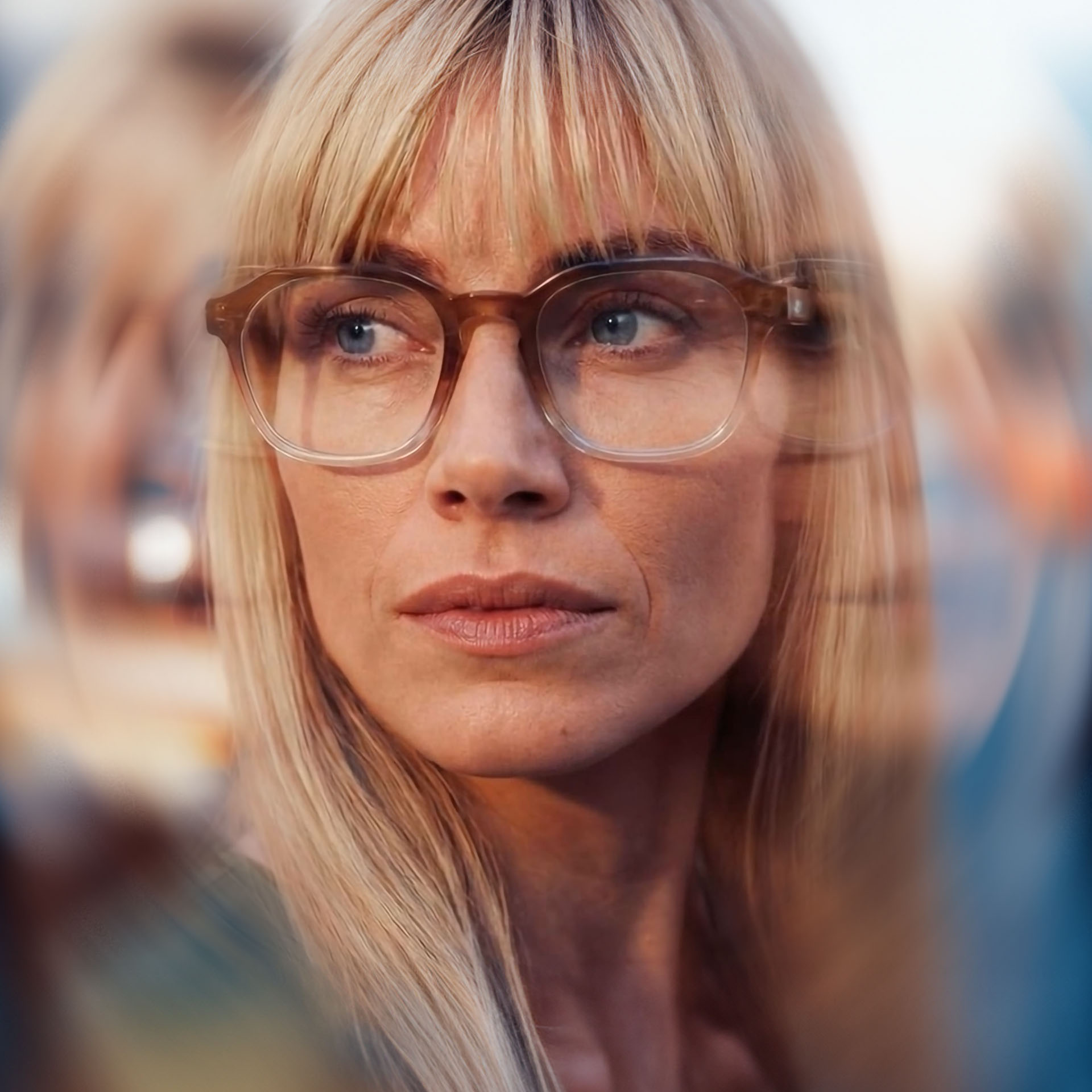 A person wearing conventional eyeglasses on a busy street with multi-exposure effects. 