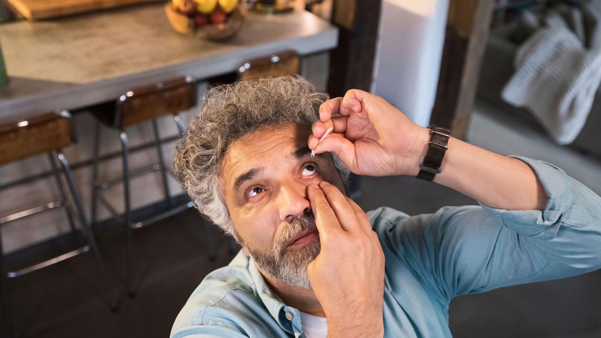 Cataract patient using eye drops after surgery.