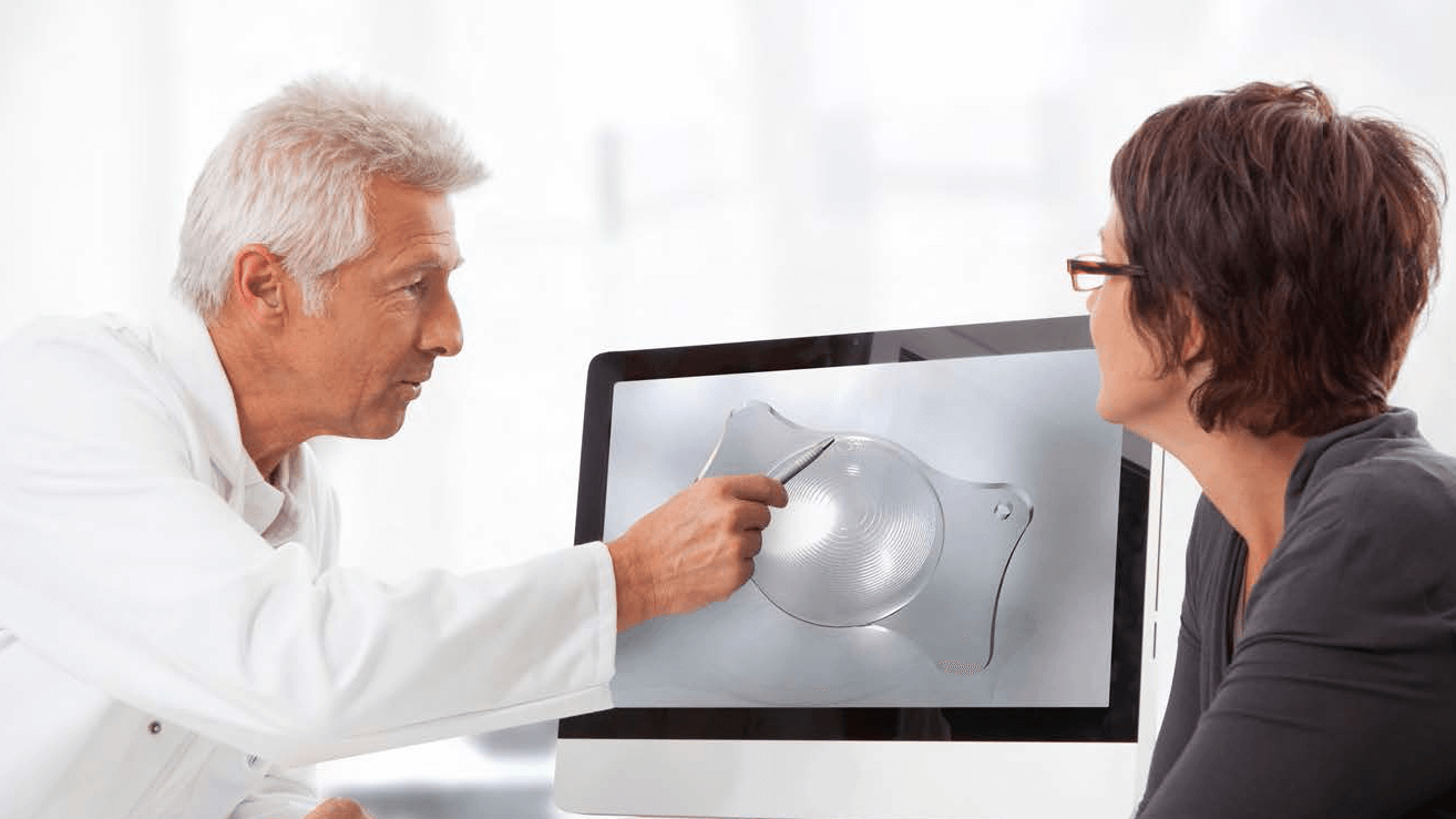 Doctor explaining a cataract lens to a patient.