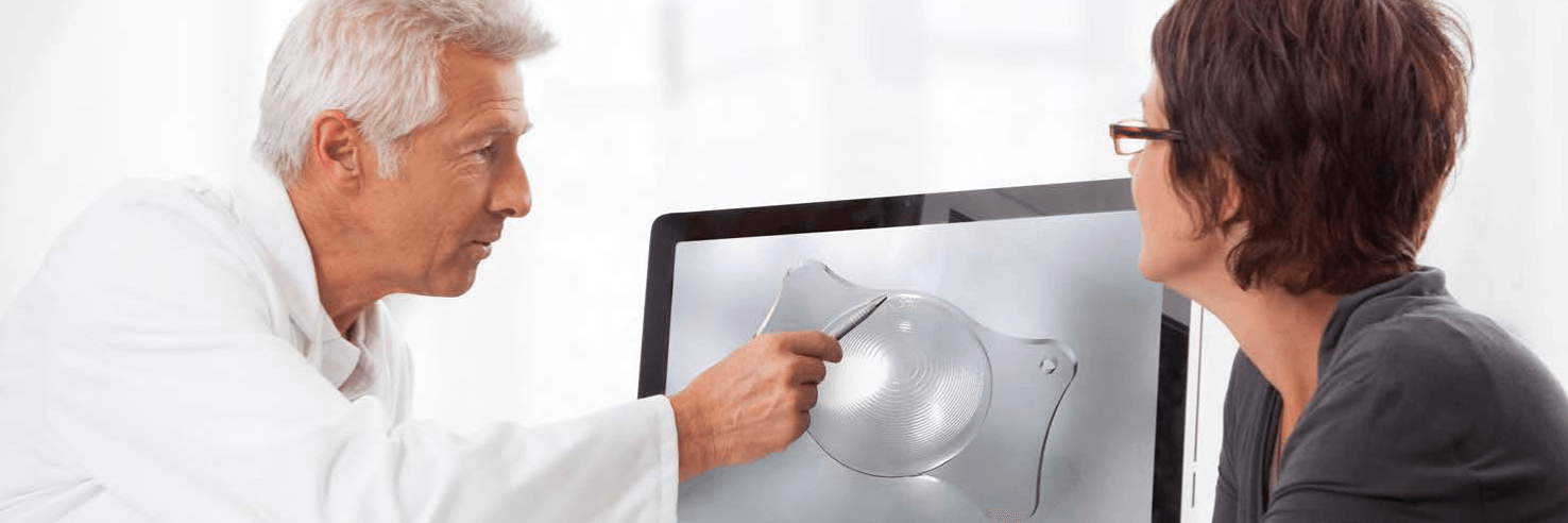 Doctor explaining a cataract lens to a patient.