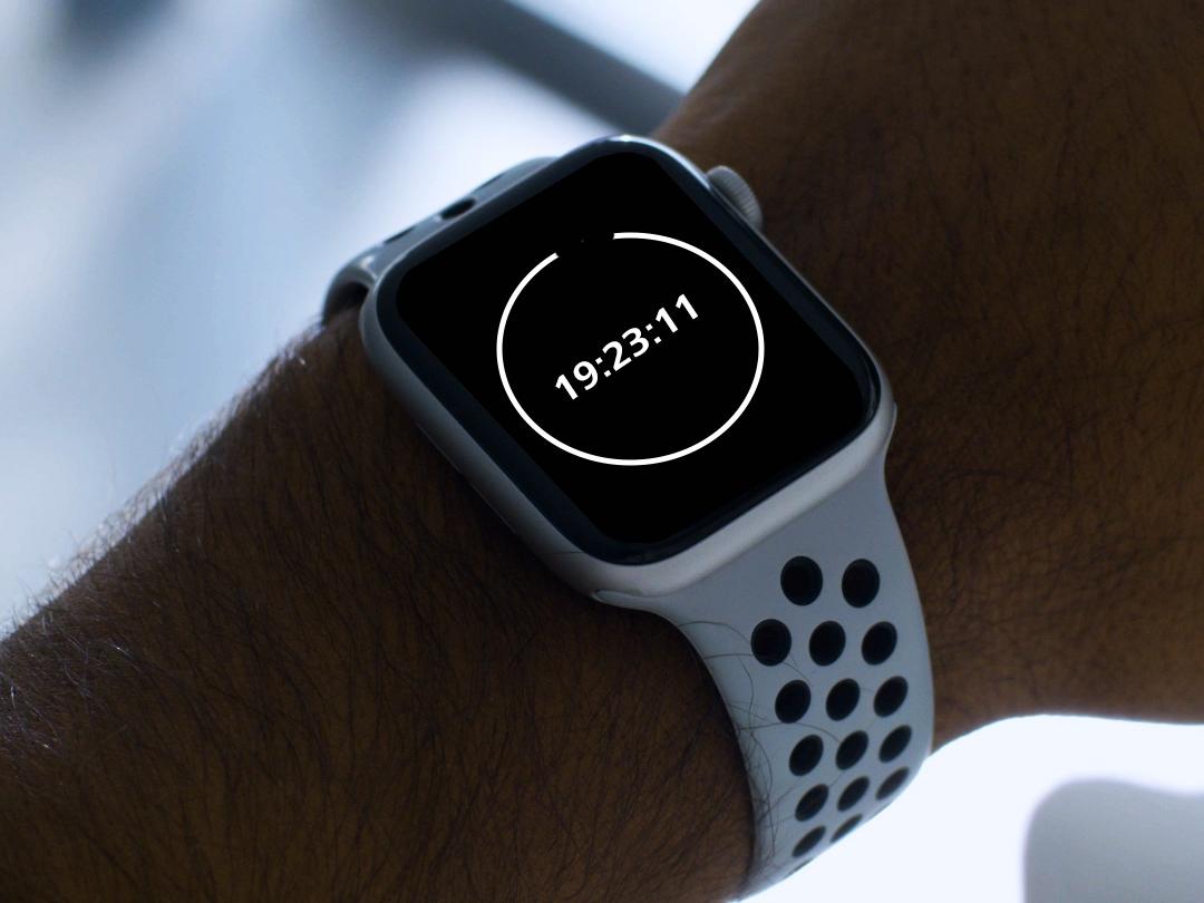 A young man wearing BlueGuard glasses, looking down at his smartwatch showing 20-minute countdown.  