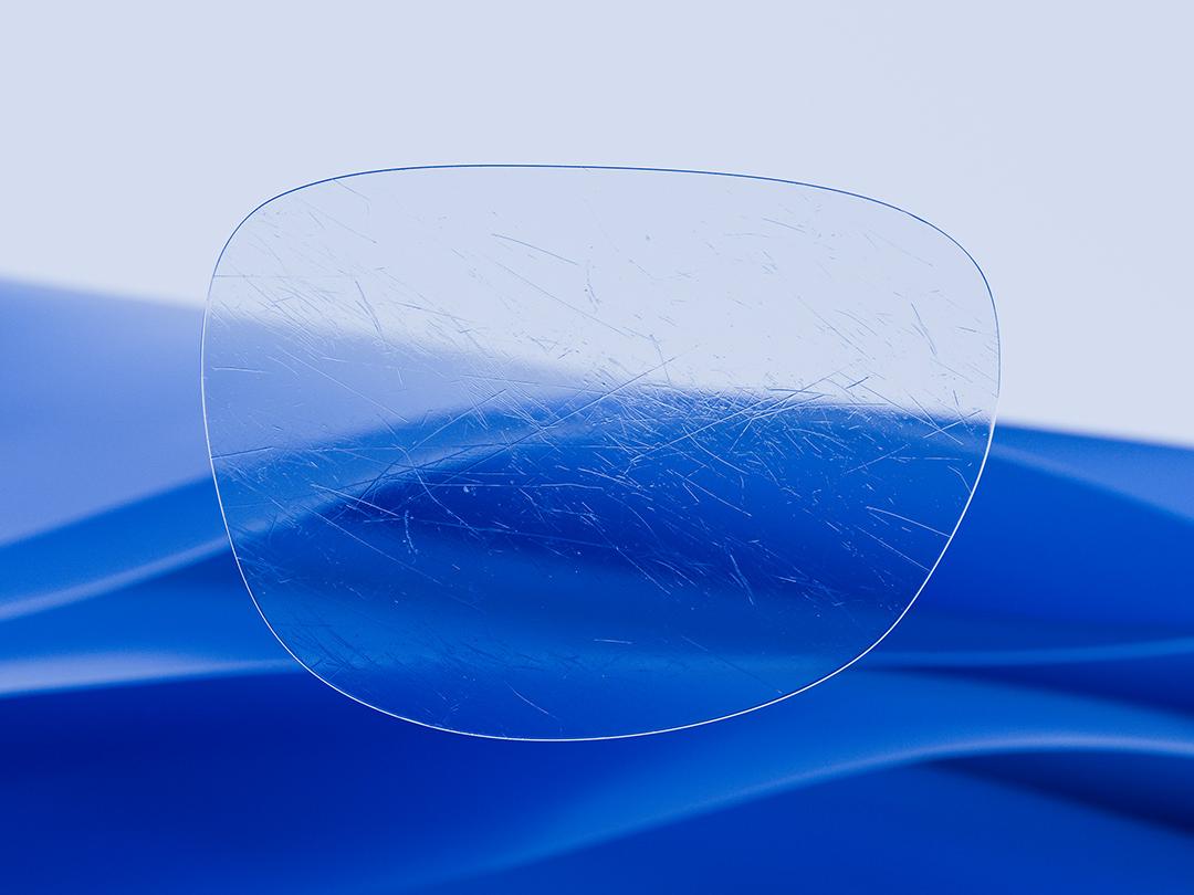 Split image showcasing a ZEISS lens on one half, characterized by its clarity and cleanliness, while the other half displays a scratched conventional eyeglass lens, highlighting the contrast in durability. 
