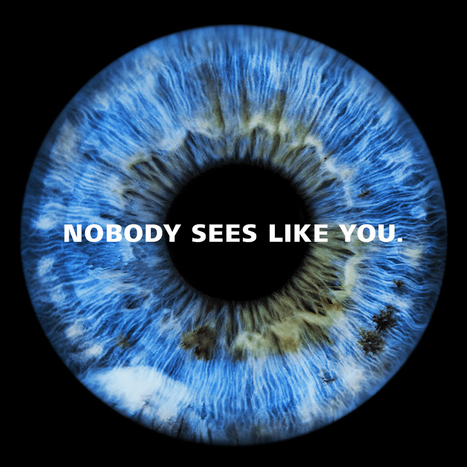 An image of a blue pupil against a black background with a text overlay that says “Nobody sees like you”.