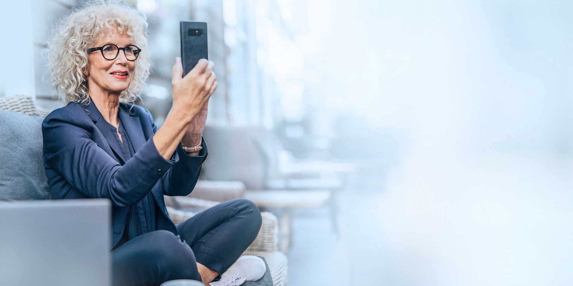 Женщина делает селфи с помощью своего смартфона