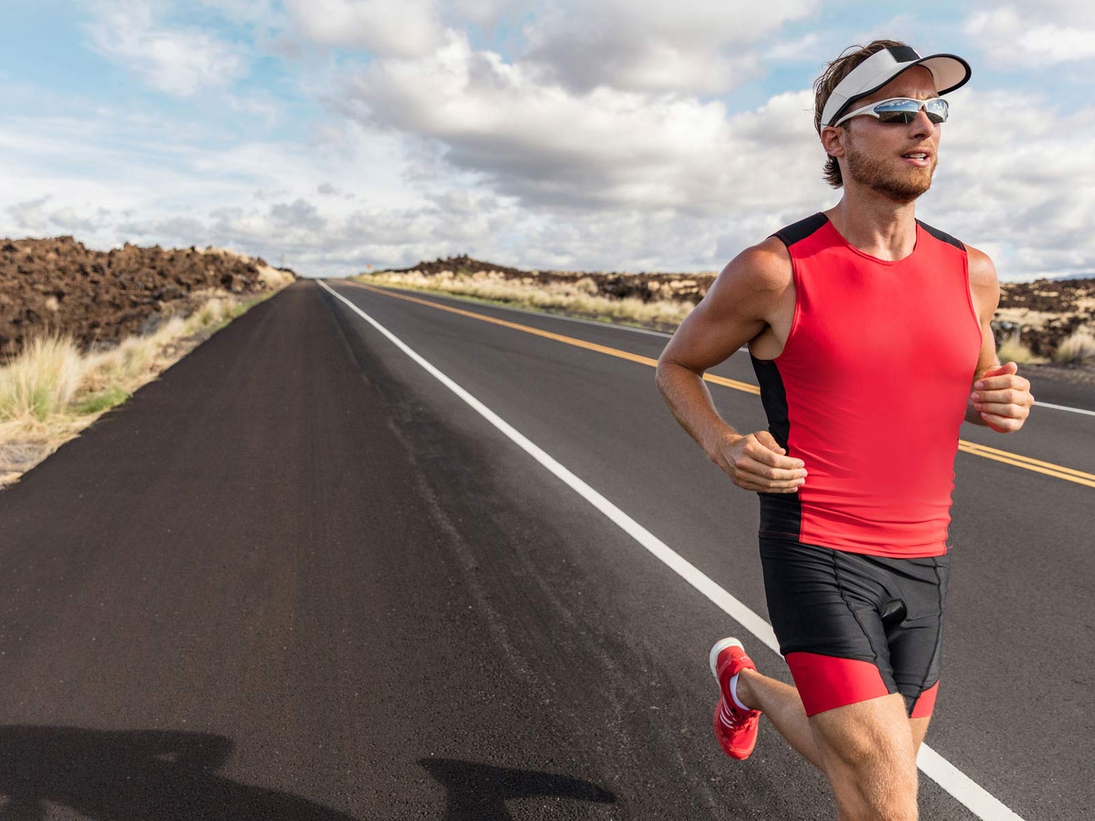 На рисунке показан человек в спортивной одежде и спортивных очках, бегущий по дороге. 