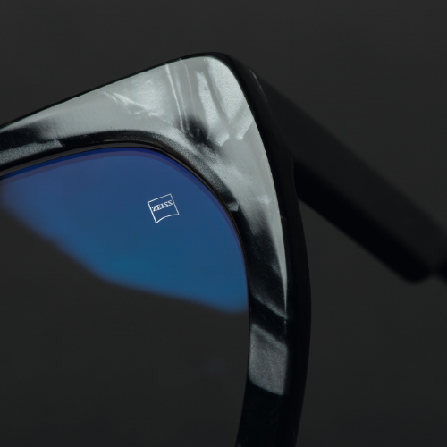 黑框眼鏡上的鏡片特寫圖片，蔡司刻印標誌清晰可見。 