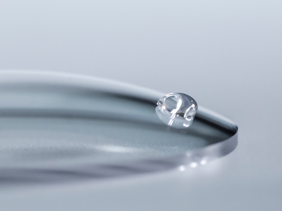A water drop slides off a ZEISS lens with an easy-clean coating.