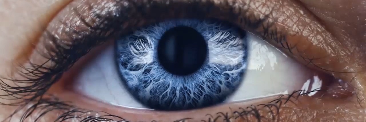 精细的抽象线条在深蓝色背景上移动组成一只眼睛的瞳孔和虹膜。
