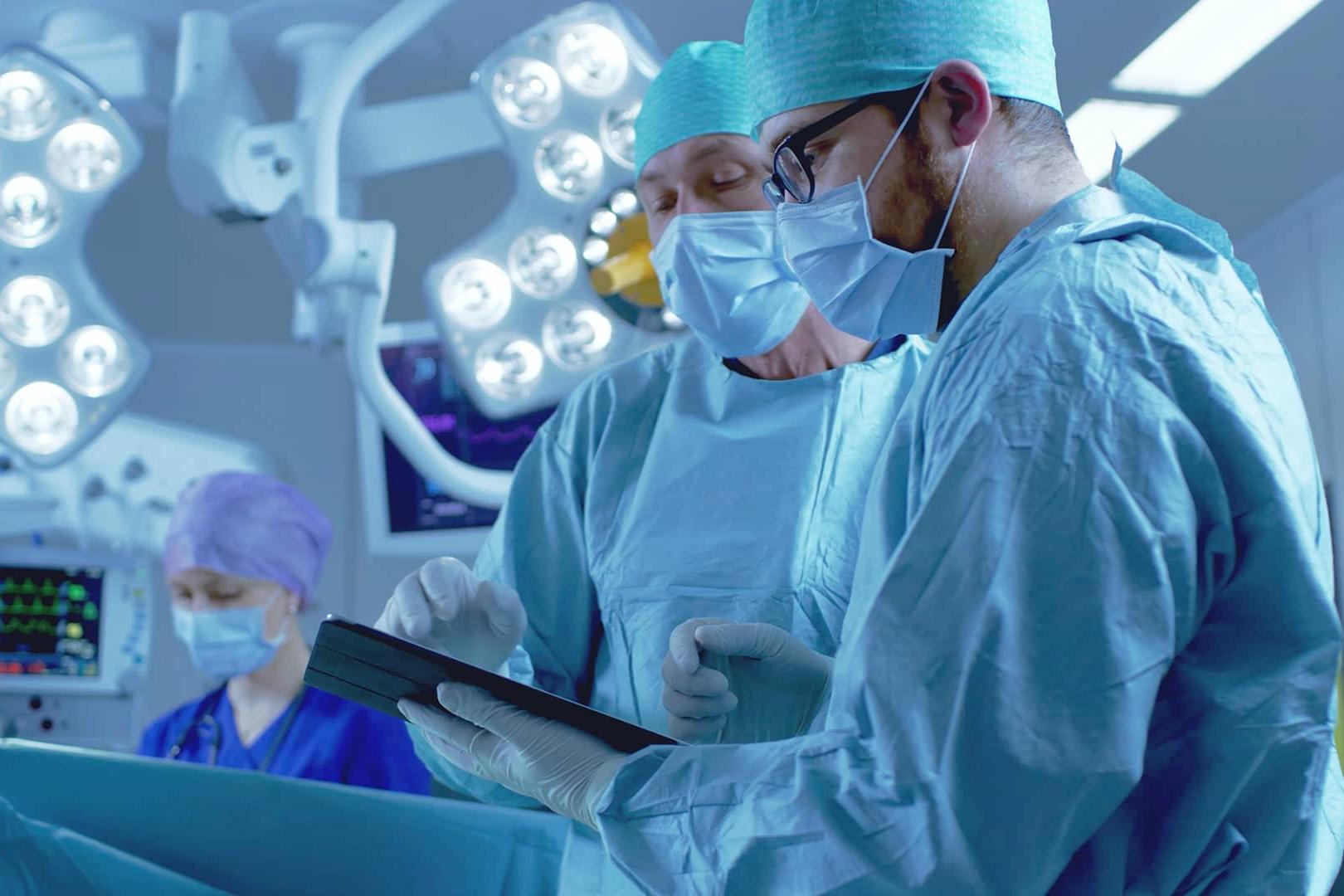 Two doctors working on a tablet in the OR.