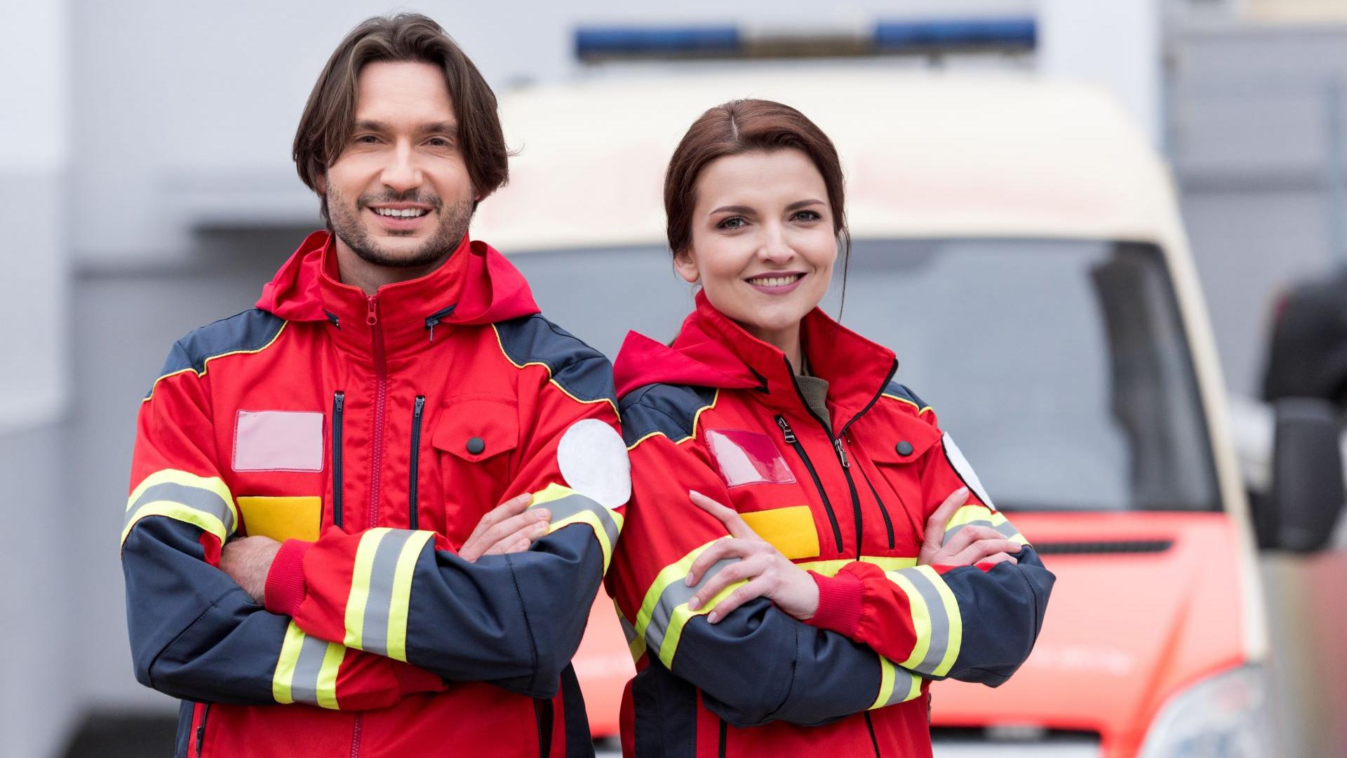 Telemedicine Solutions for Ambulances - Two paramedics standing in front of an ambulance car.