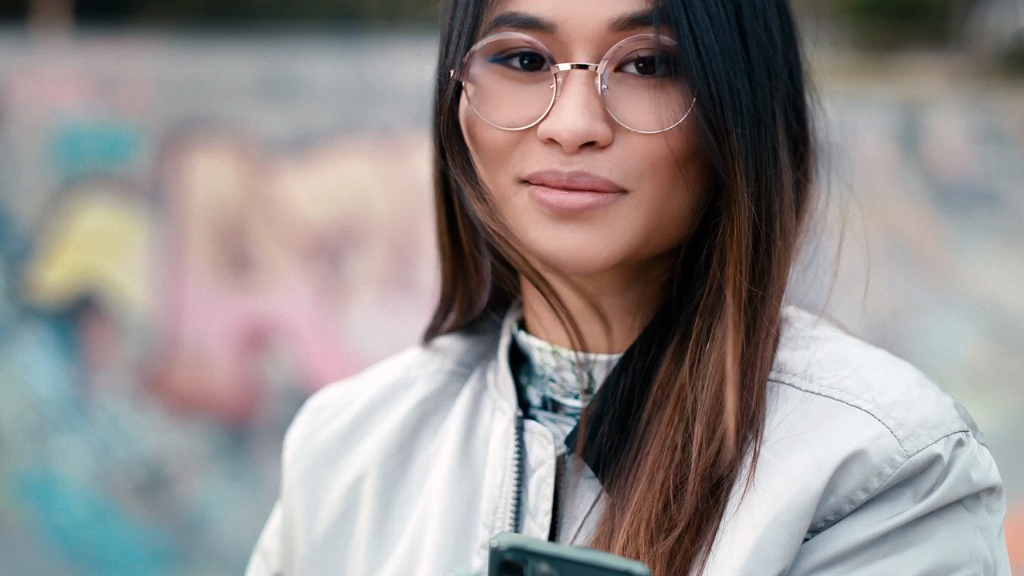 Молодая женщина в монофокальных линзах ZEISS SmartLife в скейт-парке.